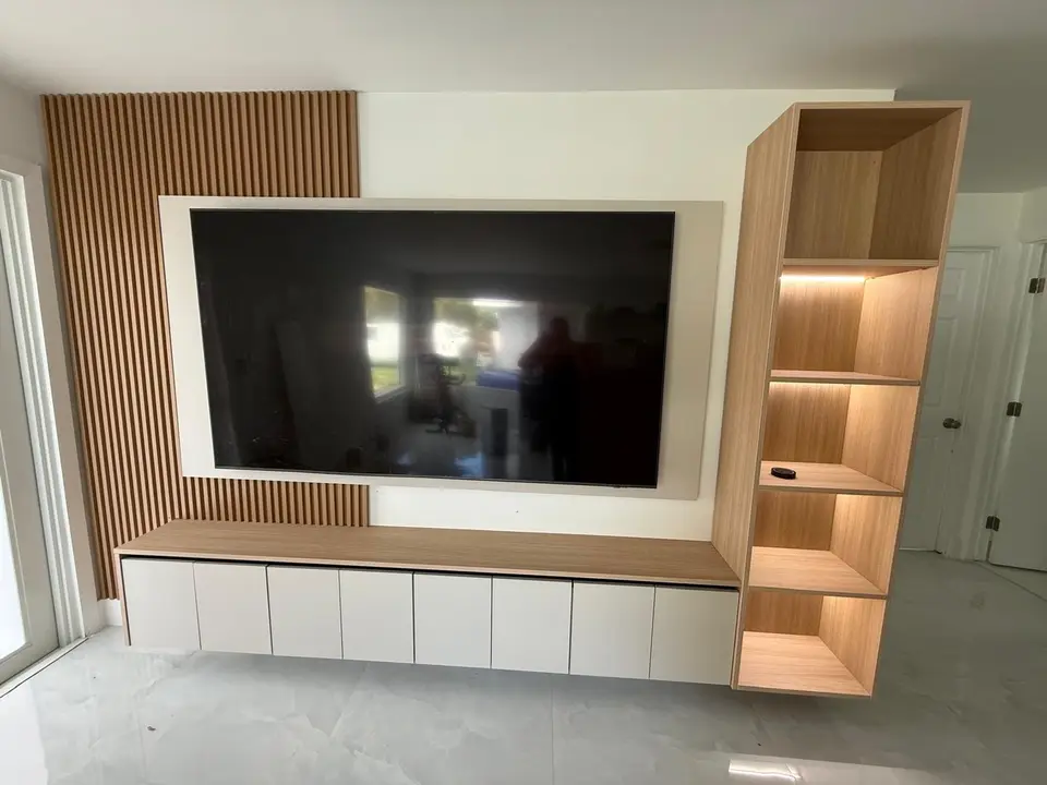Oak slat media wall with floating cabinet and backlit shelving
