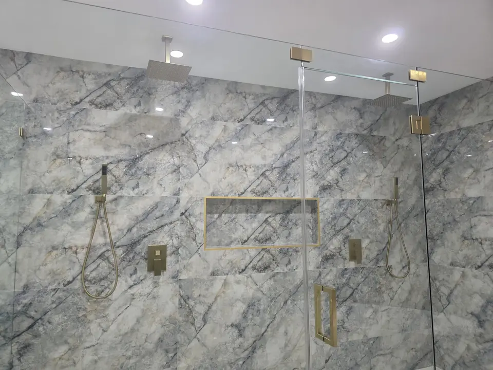 Shower with blue-gray quartzite-look walls, brass niche and handheld shower
